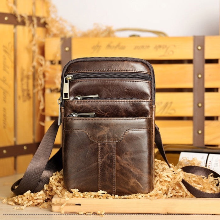 Coffee leather crossbody waist bag TC2014 styled beside a wooden crate - Touch and Catch NZ
