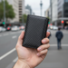 Men's RFID carbon fiber tri-fold wallet TC309 held upright in hand on Auckland city street
