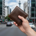 Genuine leather RFID bi-fold wallet TC3202 held in hand on Auckland street