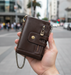 Genuine leather bi-fold wallet TC329 with chain held in hand on Auckland street
